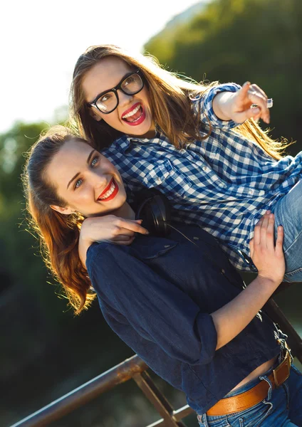 Dos jovenes juguetonas divirtiéndose al aire libre al atardecer —  Fotos de Stock