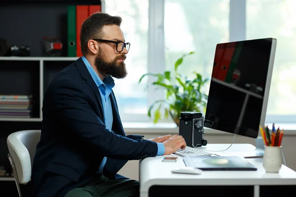 Schöner junger Mann, der von zu Hause aus arbeitet — Stockfoto