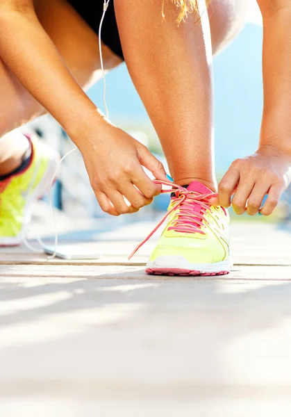 Взуття для бігу жінка зав'язує взуття мереживами — стокове фото