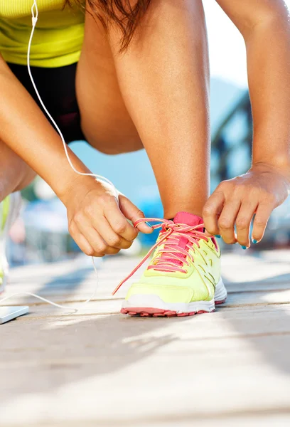Взуття для бігу жінка зав'язує взуття мереживами — стокове фото