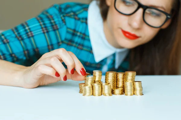 Mujer apilando monedas de oro en columnas —  Fotos de Stock