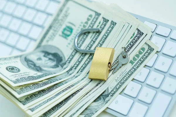 Security lock on dollar bills with white computer keyboard — Stock Photo, Image