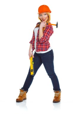 Genç kadın işçi iş araçları üzerinde beyaz bir kask