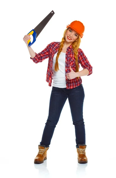 Молодая забавная работница в шлеме с пилой на белом — стоковое фото
