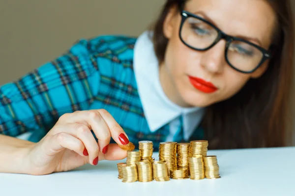 Mujer apilando monedas de oro en columnas —  Fotos de Stock