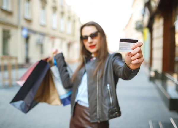 Piękna kobieta z torby na zakupy i karty kredytowej w rękach — Zdjęcie stockowe