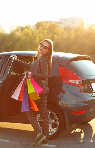 Усміхається жінка кавказька, поклавши її сумками в машину — стокове фото