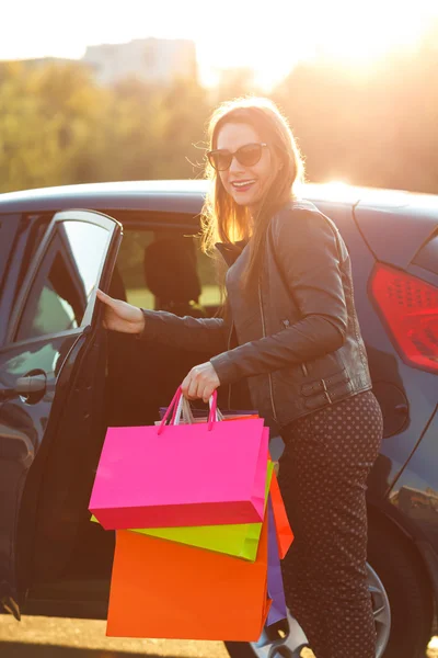 Lächelnde Kaukasierin steckt ihre Einkaufstüten ins Auto — Stockfoto