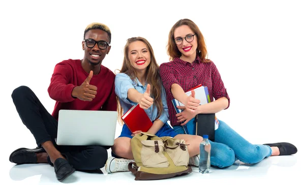 Tres jóvenes estudiantes adolescentes felices con pulgares hacia arriba aislado en w — Foto de Stock