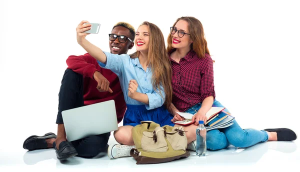 Estudiantes felices con libros, laptop, bolsas y hace selfie en whi — Foto de Stock