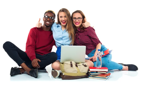 Tre elever sitter med böcker, laptop och väskor isolerad på w — Stockfoto