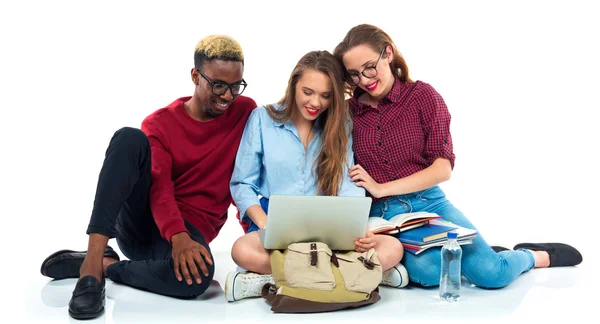 Három diák ül a könyvek, a laptop és a táskák elszigetelt w — Stock Fotó