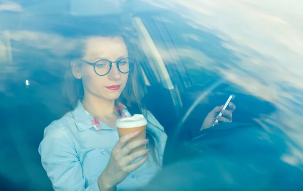 Imprenditrice inviare un messaggio di testo e bere un caffè mentre d — Foto Stock