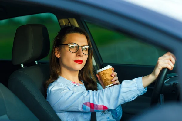 Mujer joven con café para ir conduciendo su coche —  Fotos de Stock