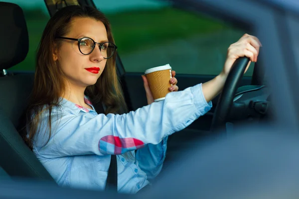 Jovem com café para ir dirigindo seu carro — Fotografia de Stock