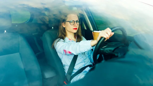 彼女の車を運転して行くにコーヒーを持つ若い女性 — ストック写真