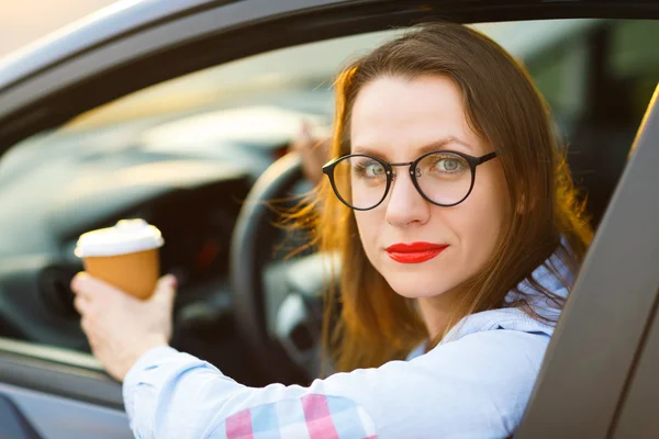 Jovem com café para ir dirigindo seu carro — Fotografia de Stock