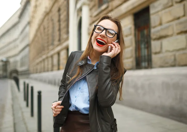 Mujer de negocios caminando por la calle mientras habla en pho inteligente — Foto de Stock