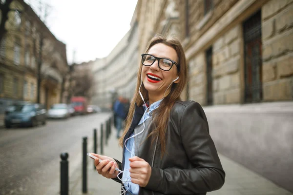 Mujer de negocios caminando por la calle mientras habla en pho inteligente —  Fotos de Stock