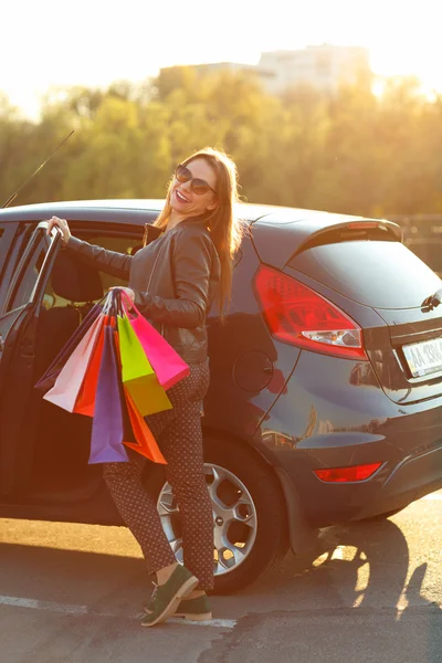 Lächelnde Kaukasierin steckt ihre Einkaufstüten ins Auto — Stockfoto