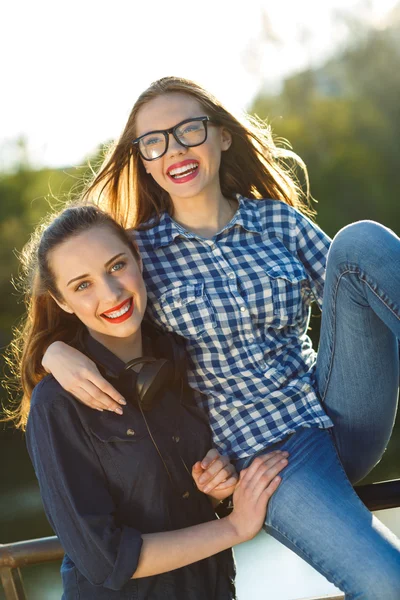 Dos chicas juguetonas divirtiéndose al aire libre al atardecer —  Fotos de Stock