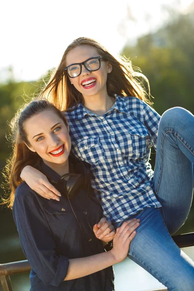 Two playful girls having fun outdoors at sunset light — Stock Photo, Image