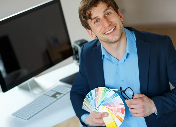 Jonge man op zoek naar een kleurenpalet van de verf — Stockfoto