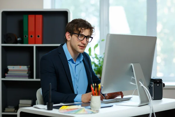 Schöner junger Mann, der von zu Hause aus arbeitet — Stockfoto