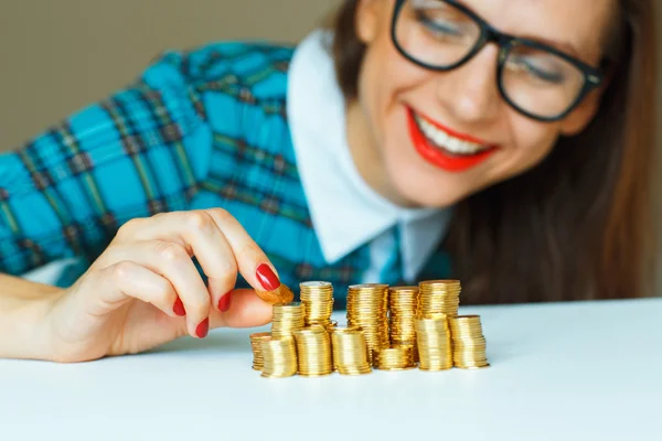 Mujer apilando monedas de oro en columnas crecientes —  Fotos de Stock
