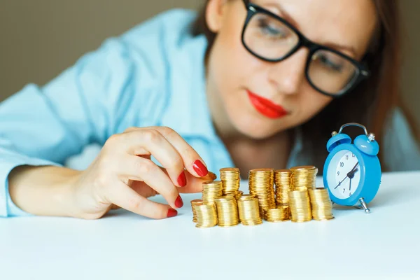 Mujer apilando monedas de oro en columnas crecientes —  Fotos de Stock