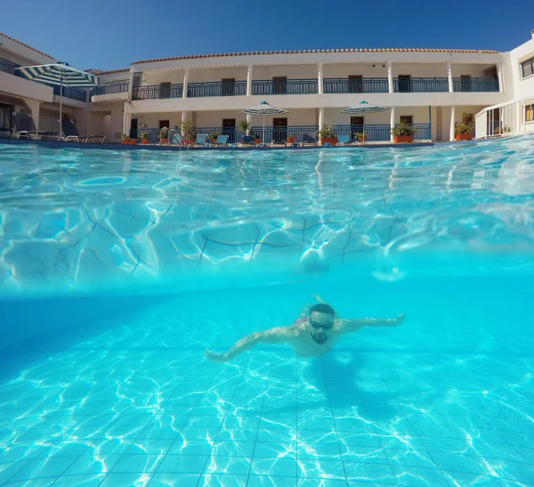 Barba hombre con gafas nadando bajo el agua en la piscina en un tro — Foto de Stock