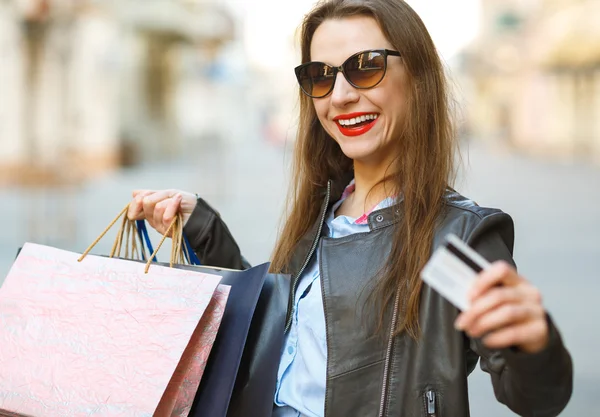 Piękna kobieta z torby na zakupy i karty kredytowej w rękach — Zdjęcie stockowe