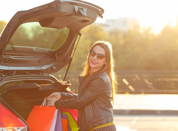 Sorridente donna caucasica mettendo le borse della spesa in macchina t — Foto Stock