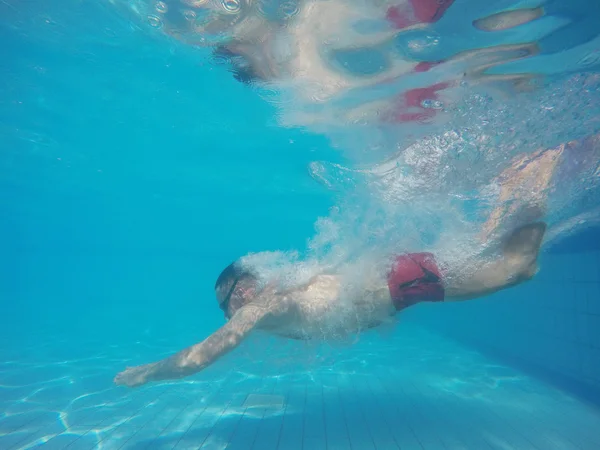 Бородач в очках ныряет в бассейн — стоковое фото