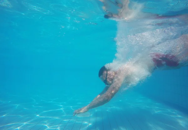 Бородач в очках ныряет в бассейн — стоковое фото