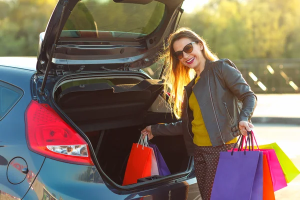 Kaukasierin legt ihre Einkaufstüten in den Kofferraum — Stockfoto