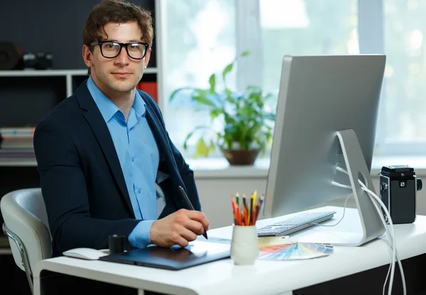 Schöner junger Mann, der von zu Hause aus arbeitet — Stockfoto