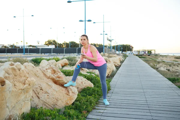 Γυναίκα ανάπαυση μετά το τρέξιμο σε ένα ξύλινο μονοπάτι στη θάλασσα — Φωτογραφία Αρχείου