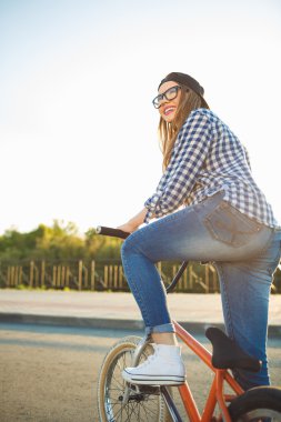Güneş ışığını bir bisiklet sürme şapkalı güzel bayanı