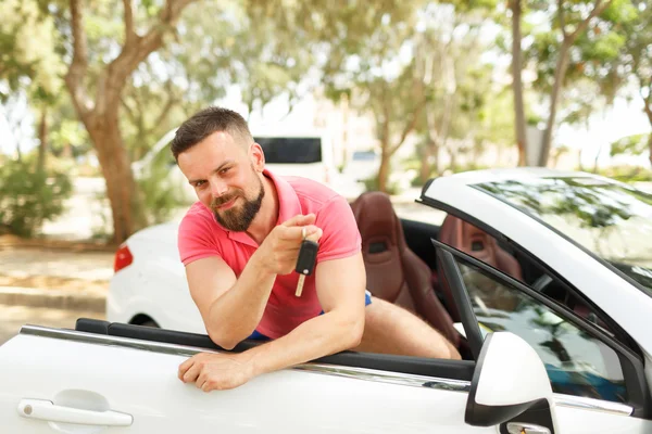 Pria berjenggot berdiri di dekat convertible dengan kunci di tangan — Stok Foto