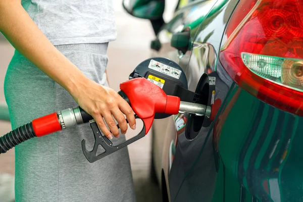 Femme remplit l'essence dans la voiture à une station-service — Photo