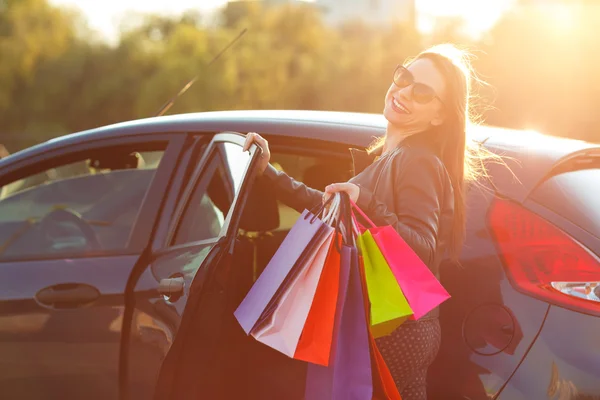 車に彼女の買い物袋を入れて白人女性 — ストック写真