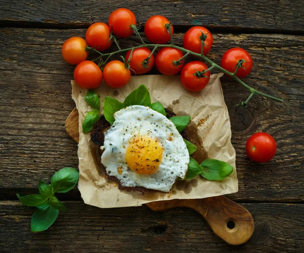 Uova strapazzate su pane tostato con basilico, spezie e ciliegia a — Foto Stock