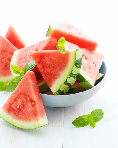 Driehoekige segmenten van verse watermeloen op witte houten achtergrond — Stockfoto