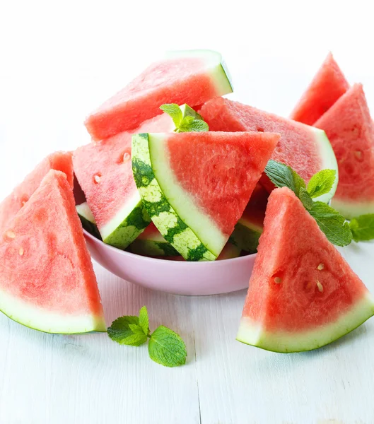 Driehoekige segmenten van verse watermeloen op witte houten achtergrond — Stockfoto