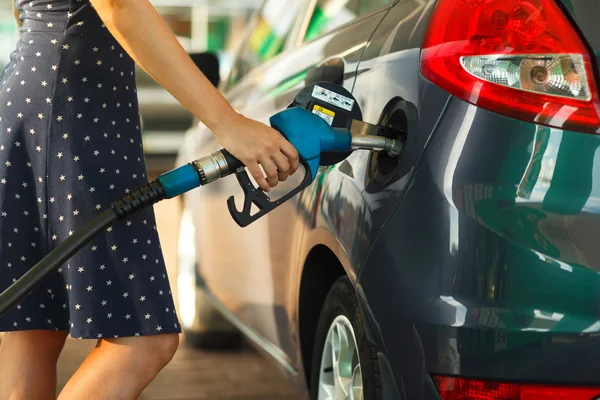 Женщина заправляет машину бензином. — стоковое фото