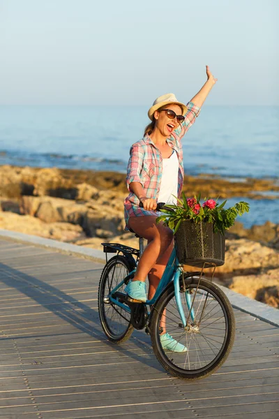 Unbekümmerte Frau mit Fahrrad auf Holzweg am Meer, — Stockfoto