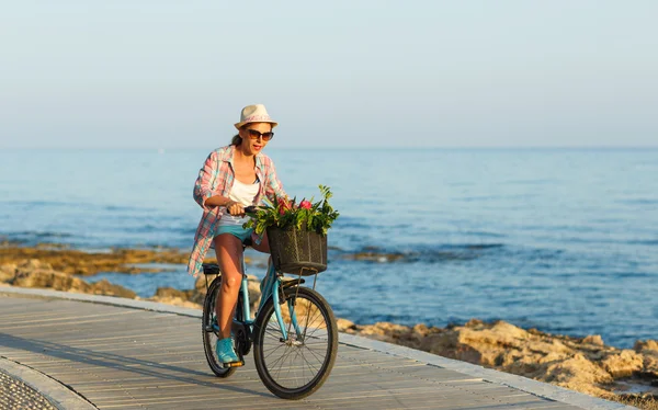 Unbekümmerte Frau mit Fahrrad auf Holzweg am Meer, — Stockfoto