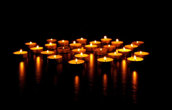 Muitas velas acesas com profundidade de campo rasa — Fotografia de Stock