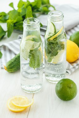 Narenciye ile infüzyon su ve nane ahşap ba üzerinde cam şişelerde